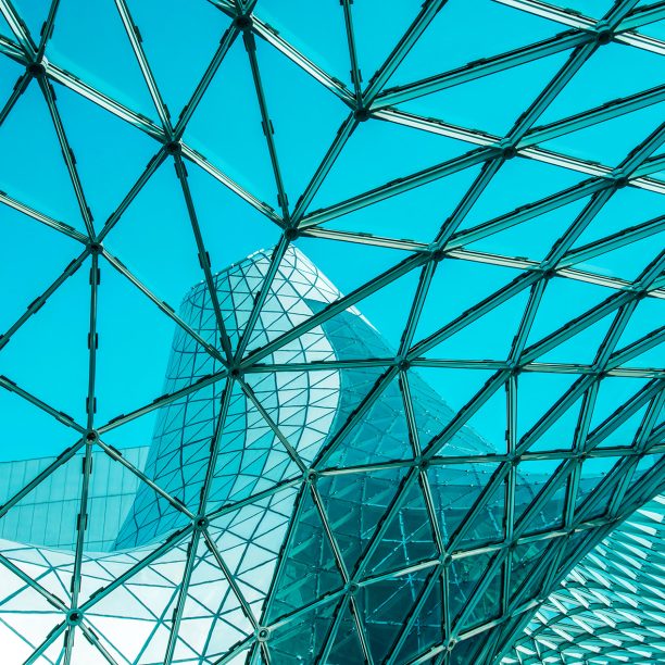 Low angle of curved glass roof with geometric shapes of modern building designed in futuristic style